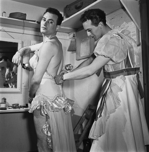 Serviceman helping his comrade get dressed in a cramped room
