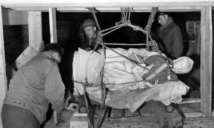 Three Monuments Men hoisting up the Madonna of Bruges via rope