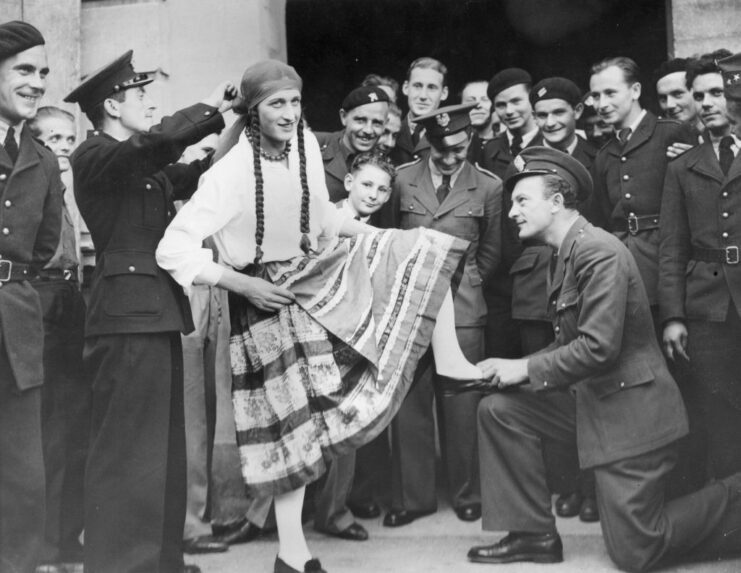 Polish airman dressed in female clothes while his comrades stand around him