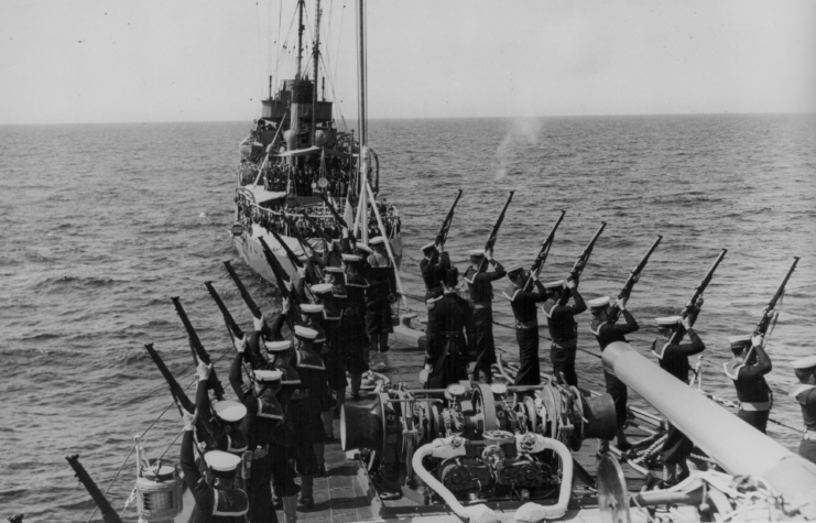 Sailors performing a naval funeral aboard two ships