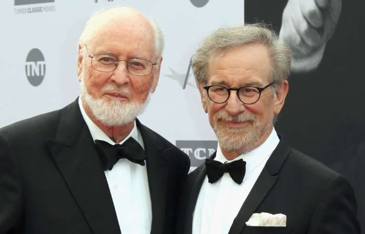 John Williams and Steven Spielberg standing on a red carpet