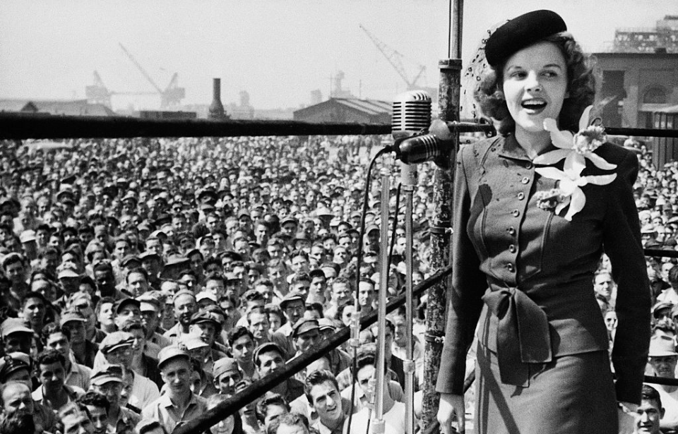 Judy Garland performing before a group of civilian workers