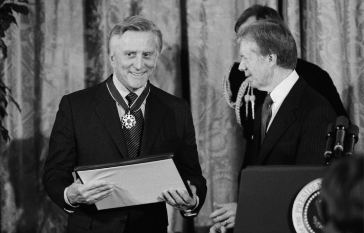 Kirk Douglas standing with Jimmy Carter on stage