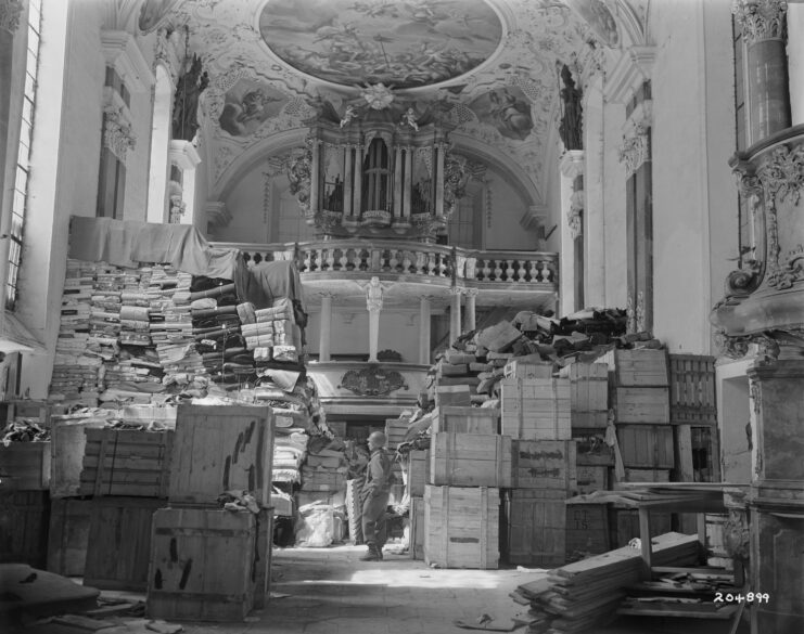 American soldier standing among piles of German loot