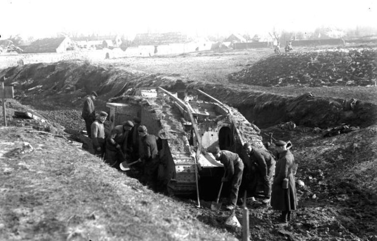 Mark IV tank being dug out of a trench by German troops