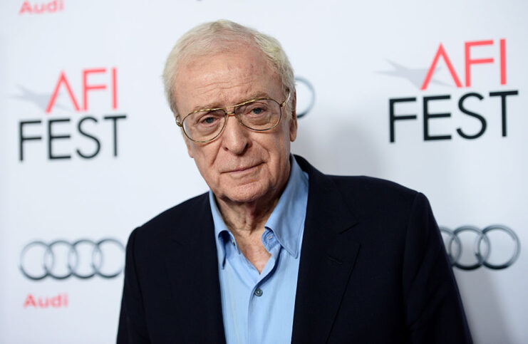 Michael Caine standing on a red carpet