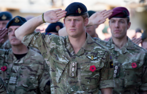 Prince Harry saluting with other British service members