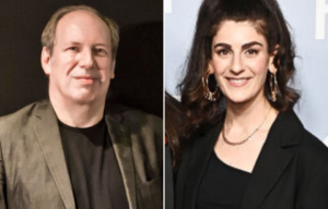 Portrait of Hans Zimmer + Kara Talve standing on a red carpet