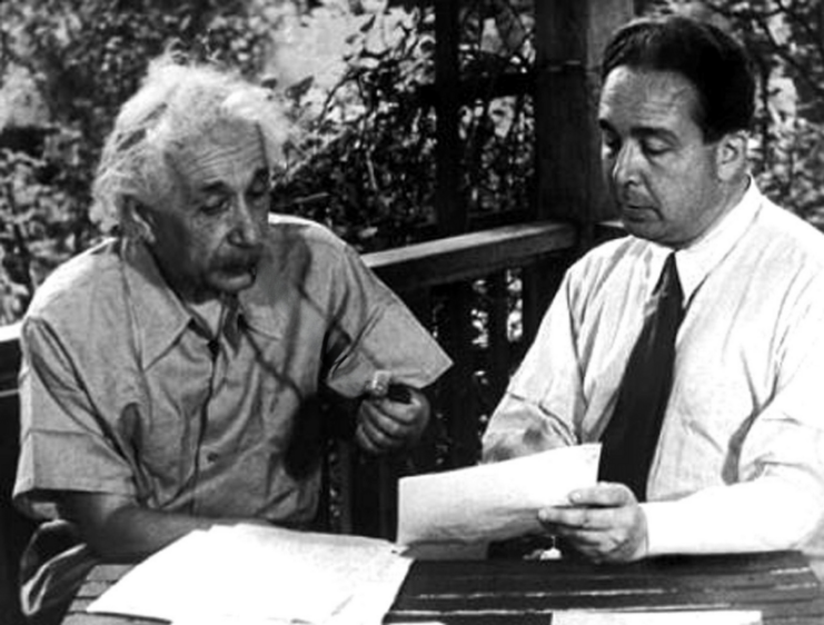 Albert Einstein and Léo Szilard sitting together, looking at a piece of paper