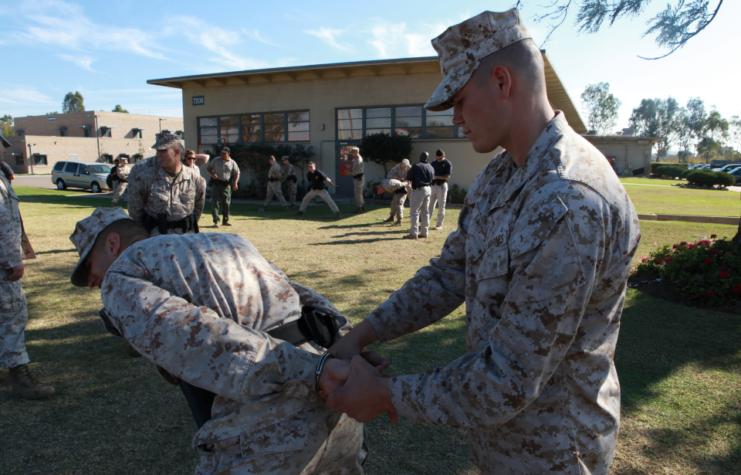 Michael Davis handcuffing Kyle Martin while other US Marines stand nearby