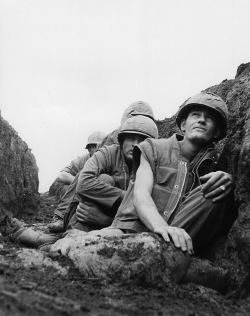 Four US Marines taking cover in a small trench