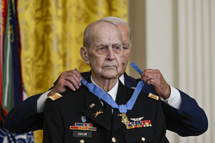 Joe Biden placing the Medal of Honor around Larry Taylor's neck