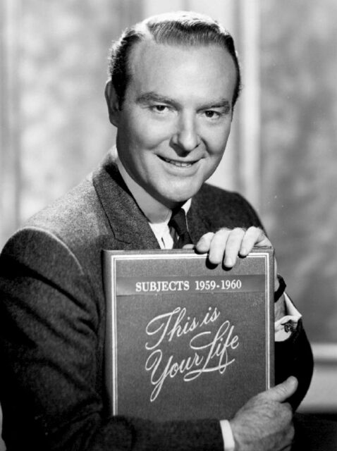 Ralph Edwards holding a folder with "This Is Your Life" scrawled on the front