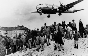 Crowd watching an aircraft fly over West Berlin