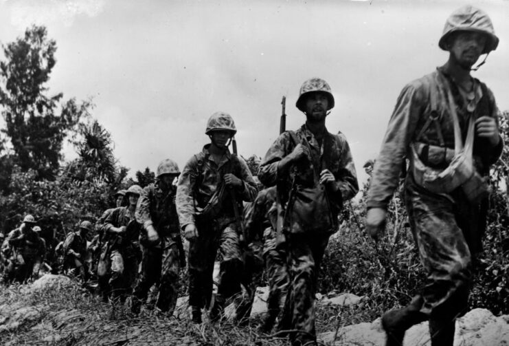 US troops walking through a field