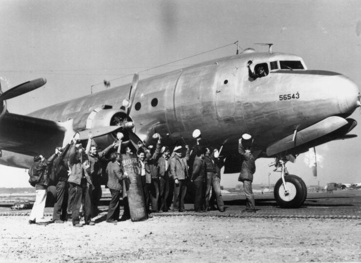 American airmen standing alongside an aircraft