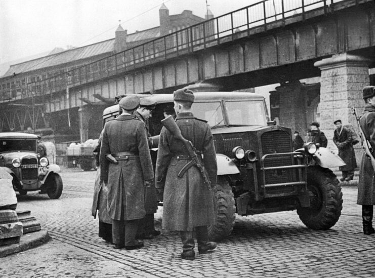 Military personnel standing around a vehicle