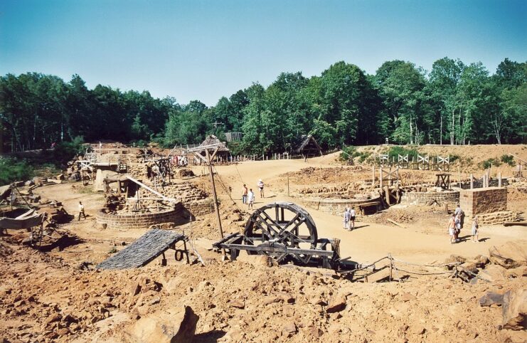 Tourists walking around a worksite dug out in the middle of a forest