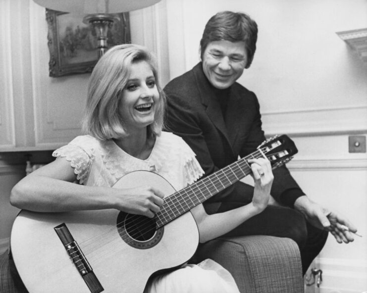 Charles Bronson watching Jill Ireland play the acoustic guitar