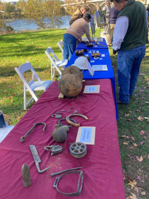 People looking at American Civil War-era artifacts laid out across three tables