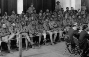 Members of the Buffalo Soldiers sitting along the side of a courtroom