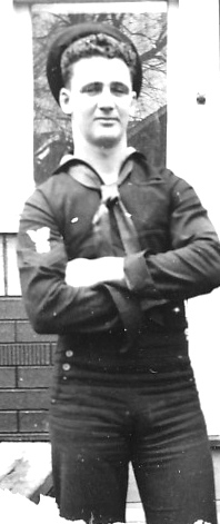 Francis P Hammerberg standing in his US Navy uniform with his arms crossed