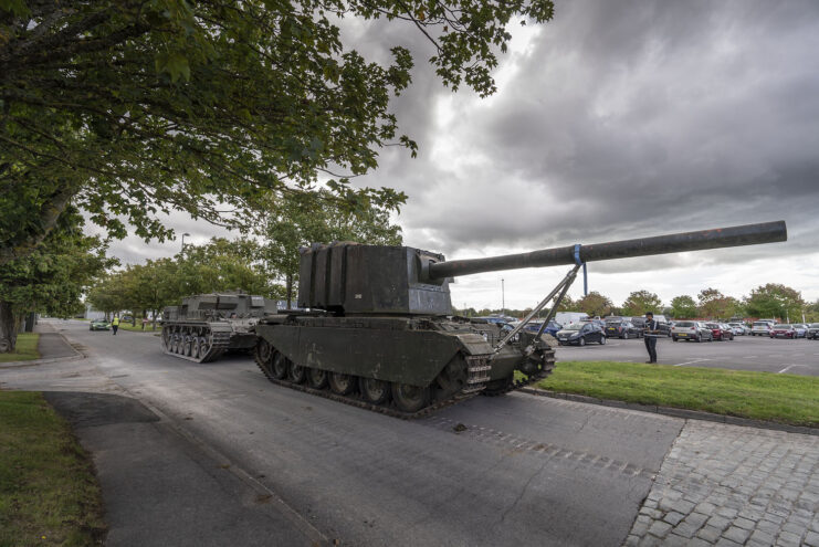 FV4005 driving along a path next to a parking lot