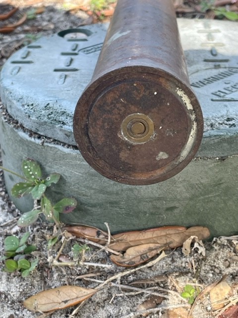 Close-up of the end of a live military round placed on a metal object outside