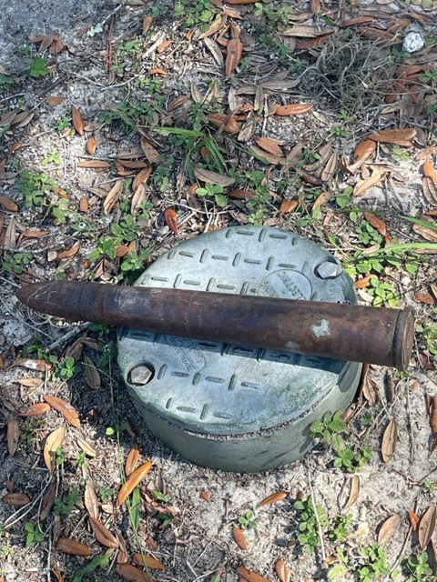 Live military round placed on a metal object outside