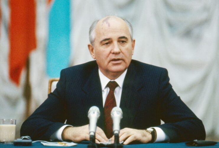 Mikhail Gorbachev sitting in front of two microphones