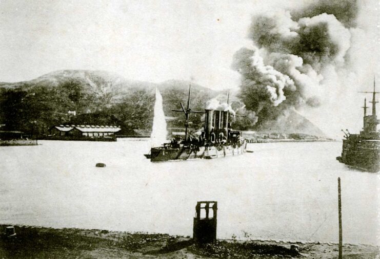 Oil depot on fire while a ship sits in the middle of the water