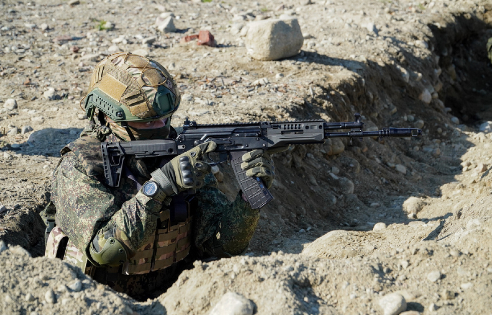 Russian soldier aiming an AK-15 from a trench