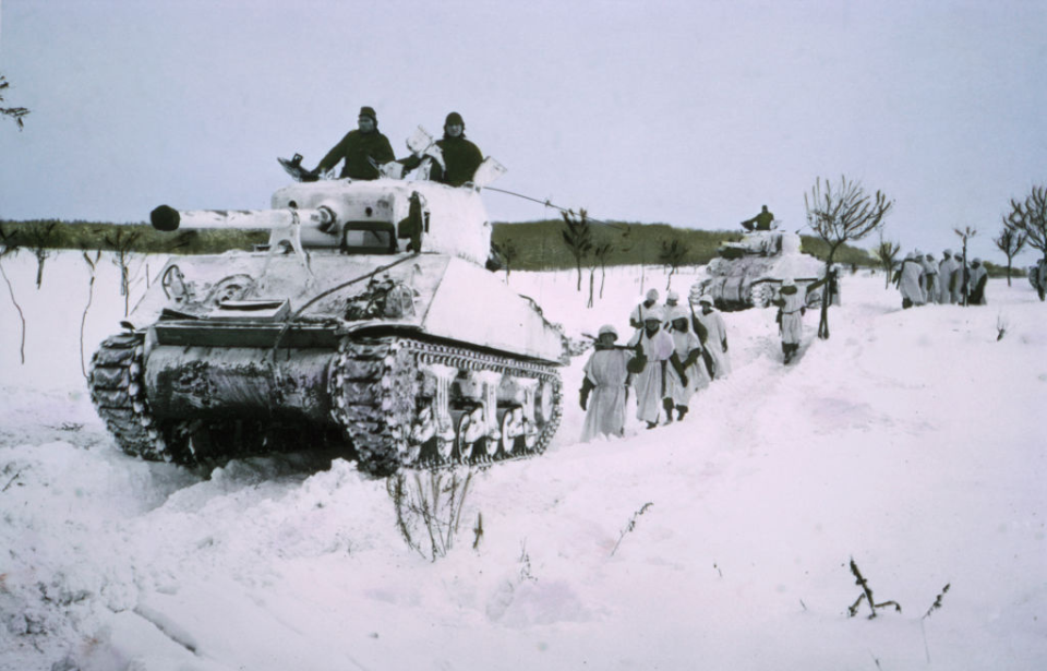 Troops and tanks moving down a snow-covered road