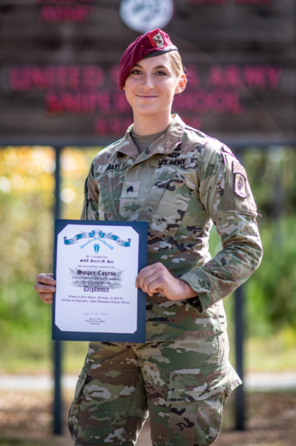 Maciel Hay standing with her US Army Sniper School certificate