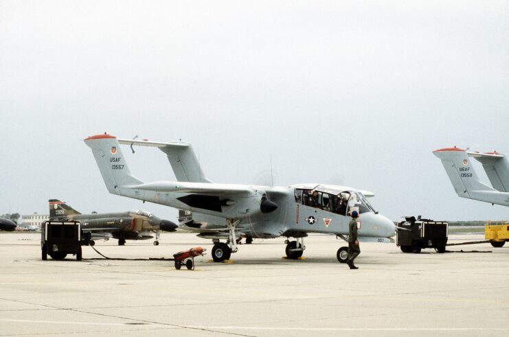 Airman walking by a North American Rockwell OV-10A Bronco parked on the tarmac