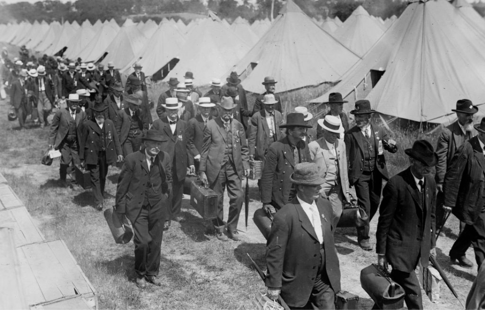 American Civil War veterans walking by tents at the 1913 Gettysburg Reunion