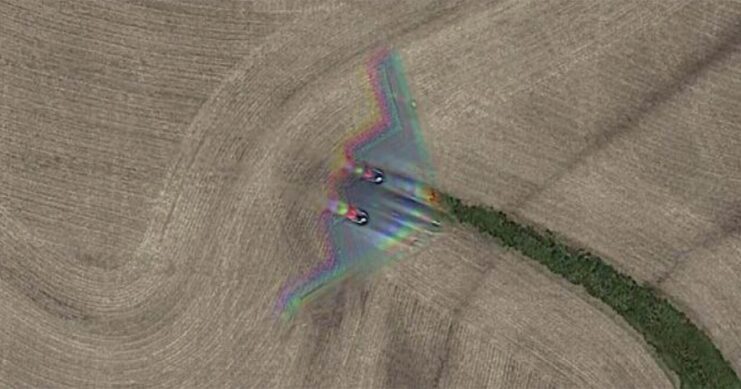 Northrop Grumman B-2 Spirit flying over a field