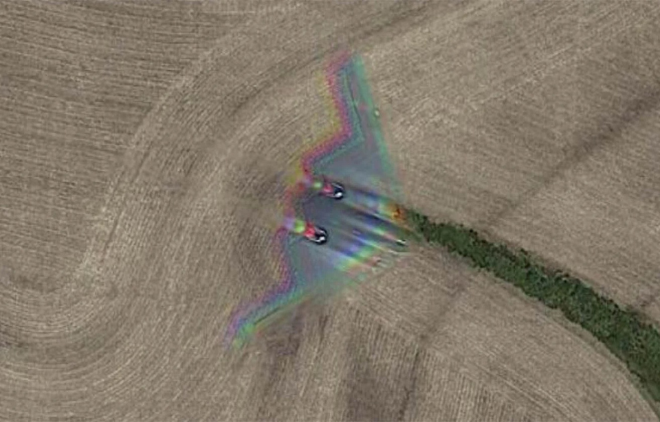 Northrop Grumman B-2 Spirit flying over a cornfield