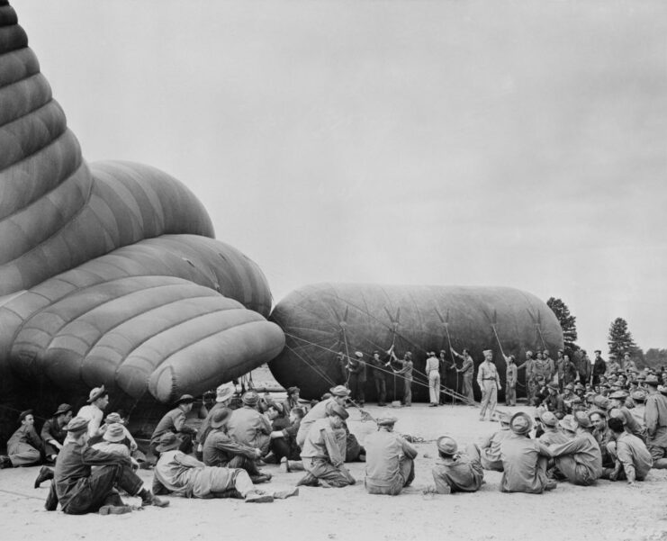 Recruits sitting around a barrage balloon