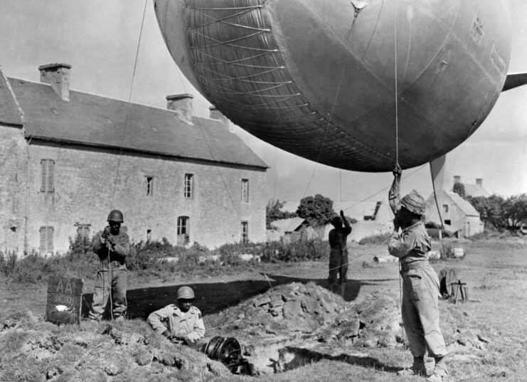 Members of the 320th Barrage Balloon Battalion mooring a barrage balloon into the ground