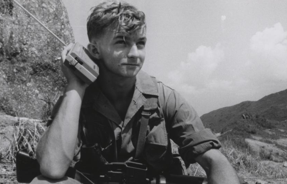 Cpl. James E. Mull holding a portable radio up to his ear