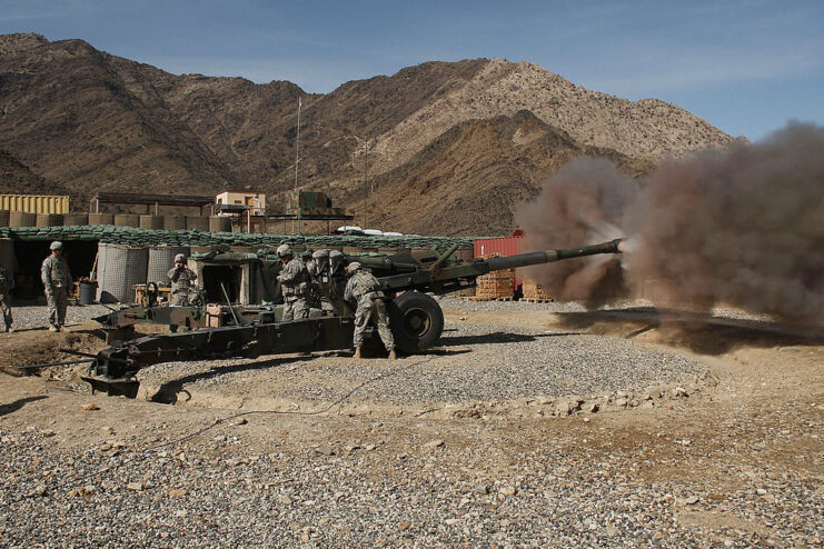 US soldiers standing around a M198 Howitzer being fired