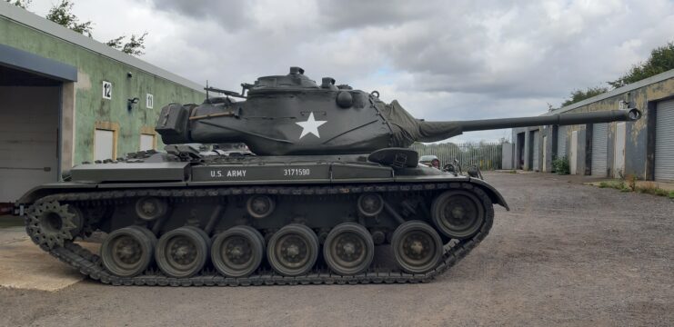M47 Patton parked between two structures