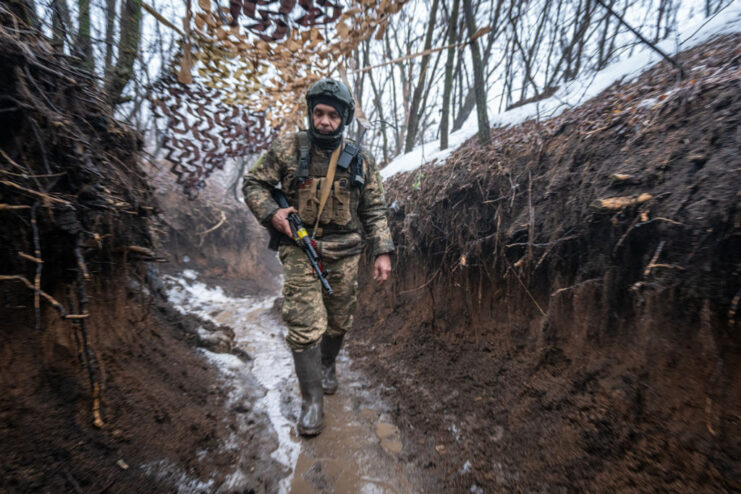 Ukrainian soldier walking through a trench