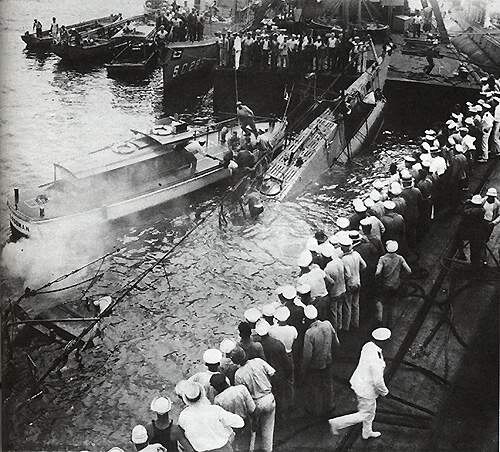 US Navy sailors watching the USS O-5 (SS-66) being pulled out of the water