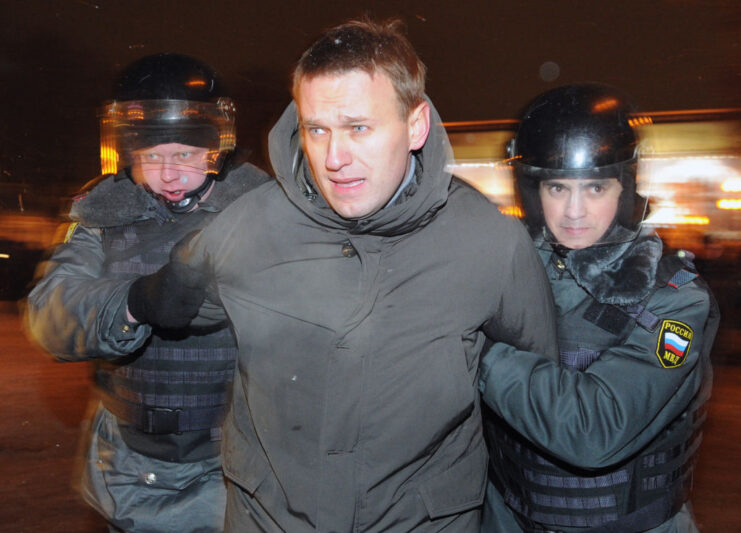 Two police officers detaining Alexei Navalny