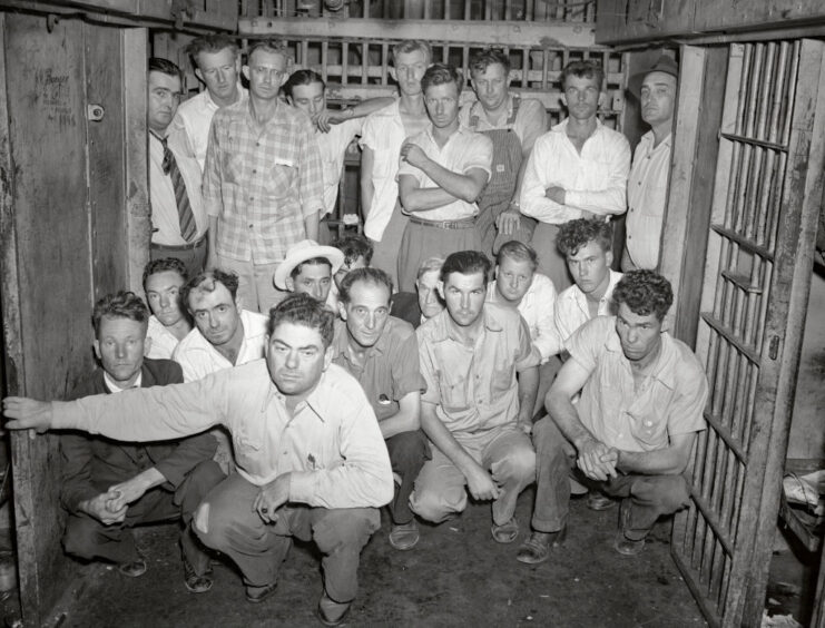 Group of deputy sheriffs standing in a jail cell
