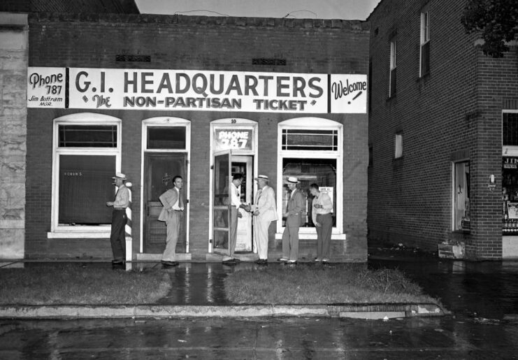 Men standing outside of the GI Non-Partisan League headquarters