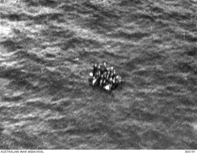 Aerial view of HMAS Armidale (J240) crewmen in a life raft at sea