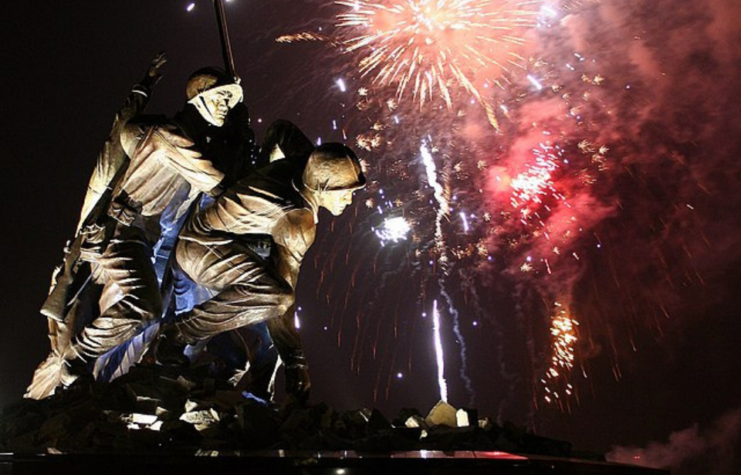 Fireworks going off in the sky behind the Iwo Jima Memorial in Fall River, Massachusetts